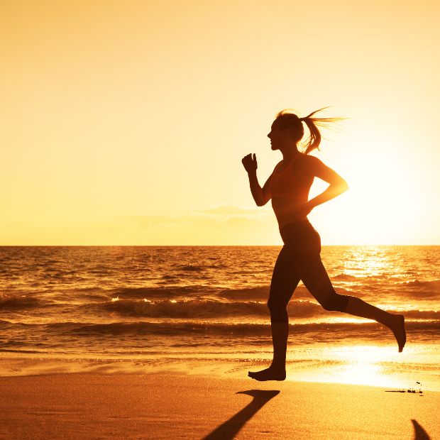 A runner on the beach at sunrise